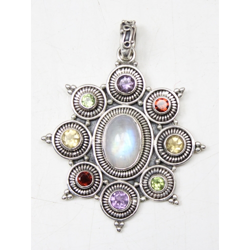 1126 - 2 silver pendants 1 set with central coloured glass stone on chain, the other with multiple coloured... 