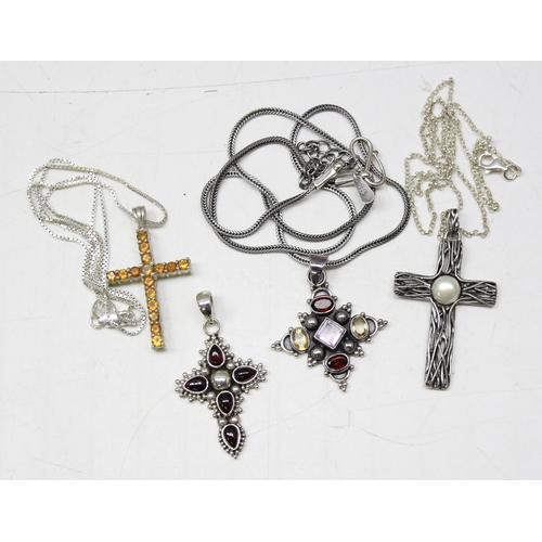 1130 - 4 silver pendants, 3 on chains to include 3 crucifixes and another gothic style pendant set with col... 