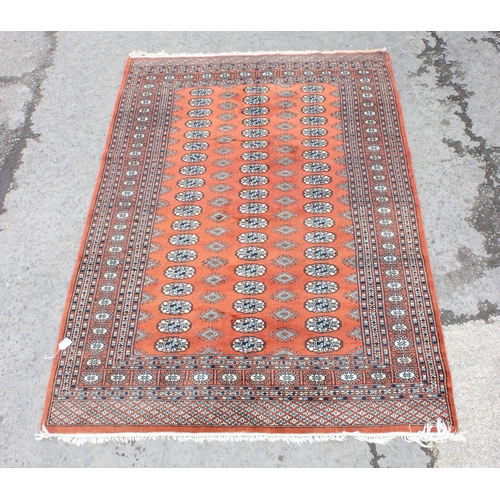 200 - A large vintage red ground Bokhara rug with 3 lines of gul, approx 240cm x 158cm