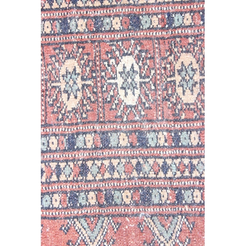 200 - A large vintage red ground Bokhara rug with 3 lines of gul, approx 240cm x 158cm