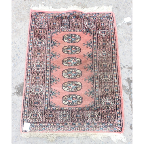 204 - A small vintage Bokhara rug on salmon ground, approx 90cm x 64cm