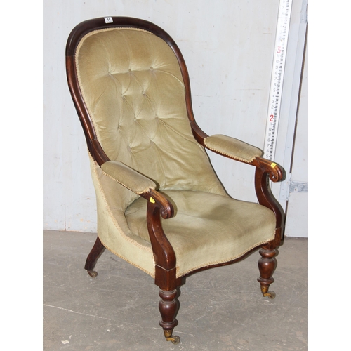 131 - A 19th century button backed low armchair with mahogany frame and brass castors