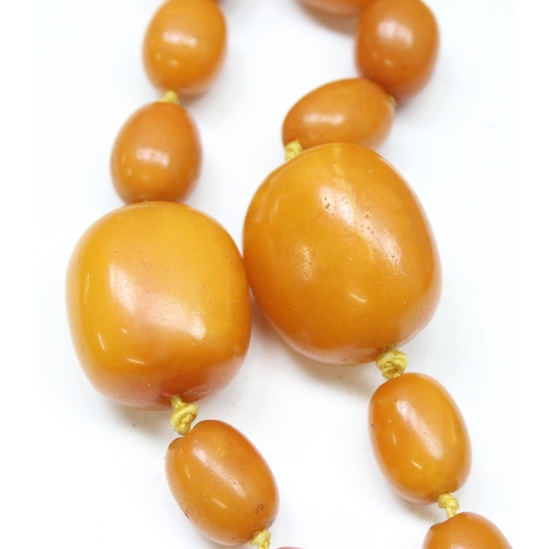 1174 - A large vintage amber coloured bead necklace, believed to be Amber on individually strung and knotte... 