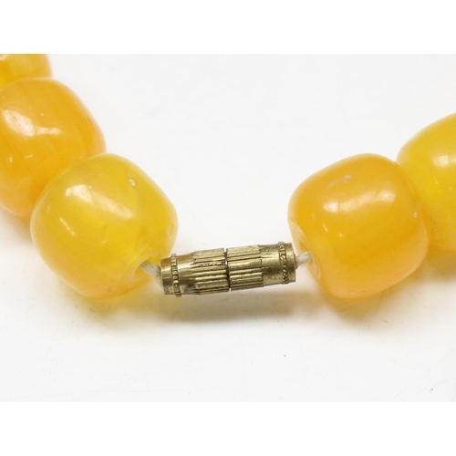 1177 - A large vintage amber coloured bead necklace with vintage brass screw clasp, the largest bead approx... 