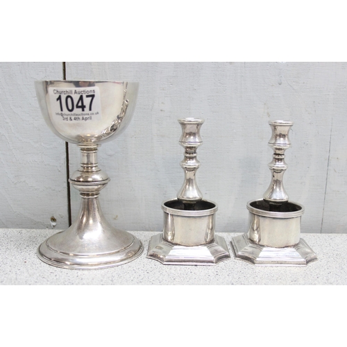 1047 - A mid 20th century silver plated travelling communion chalice and a pair of silver plated candlestic... 