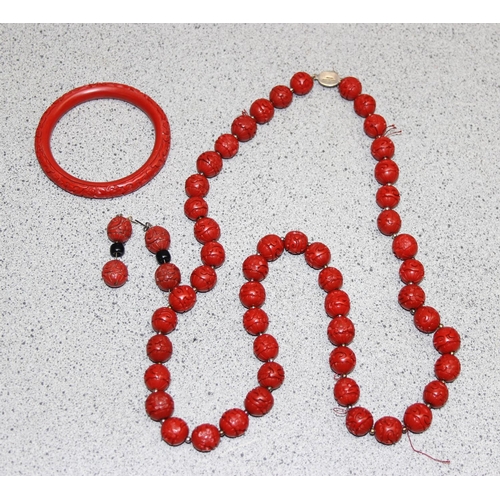 1199M - A Chinese carved bead necklace with silver clasp believed to be cinnabar lacquer, a pair of matching... 