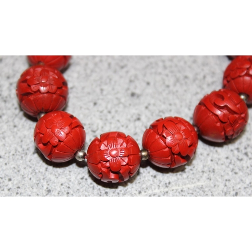 1199M - A Chinese carved bead necklace with silver clasp believed to be cinnabar lacquer, a pair of matching... 