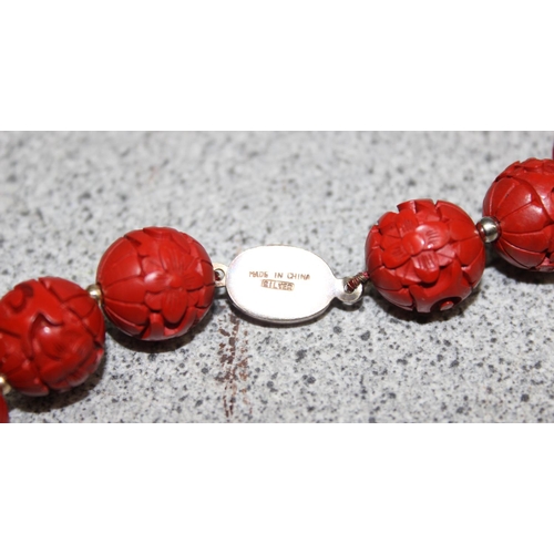 1199M - A Chinese carved bead necklace with silver clasp believed to be cinnabar lacquer, a pair of matching... 