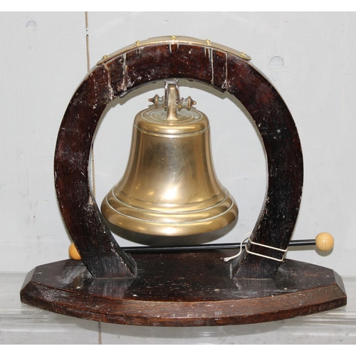 1826 - A vintage brass table bell on wooden horseshoe shaped stand, approx 33cm wide