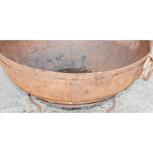 353 - A rusty metal garden fire pit or brazier on metal stand, approx 71cm in diameter