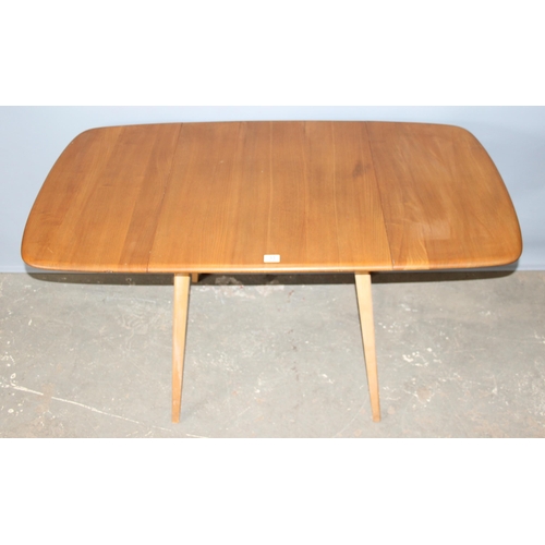 33 - A retro blonde Ercol drop leaf dining table with elm top, with blue & gold label, approx 140cm x 75c... 