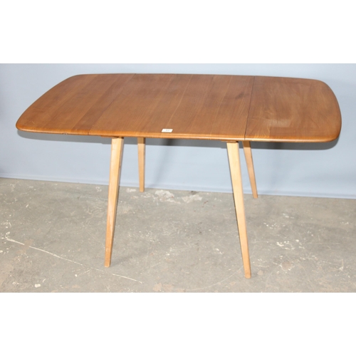 33 - A retro blonde Ercol drop leaf dining table with elm top, with blue & gold label, approx 140cm x 75c... 