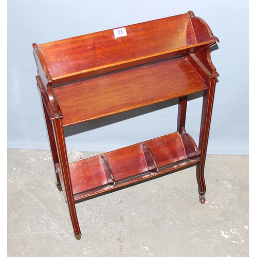 85 - An Edwardian Sheraton revival 2 tier mahogany book trough with brass and ceramic castors