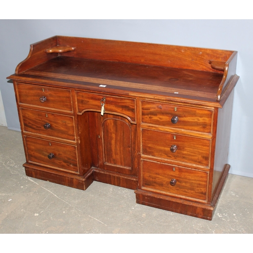 66 - A late 19th century mahogany kneehole desk with 7 drawers and a single cupboard with back rail and c... 