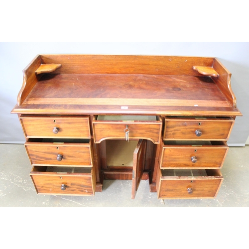 66 - A late 19th century mahogany kneehole desk with 7 drawers and a single cupboard with back rail and c... 