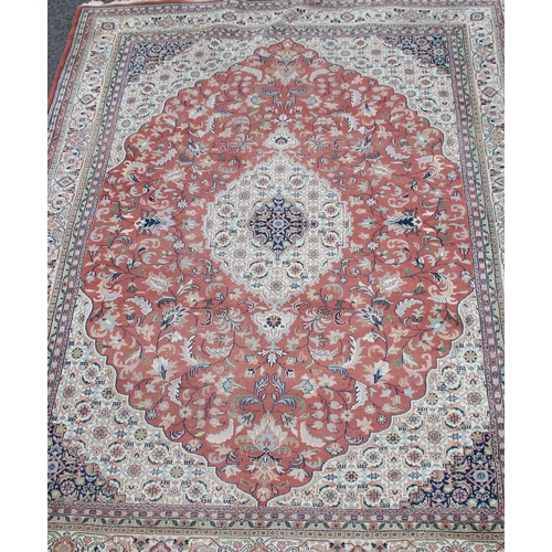 200 - A large Indo-Persian rug of pink/ red ground with various decorative borders, approx 335cm x 224cm, ... 