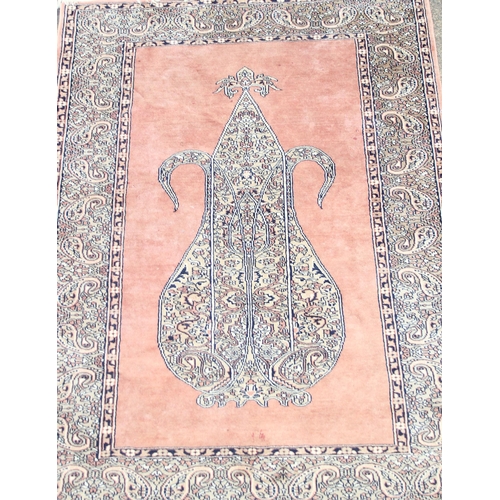 202 - A vintage salmon ground prayer rug, approx 200cm x 130cm