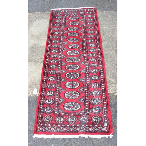 214 - A vintage red ground Bokhara runner rug, approx 240cm x 66cm