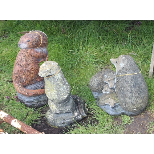 329 - 3 painted concrete garden ornaments to include 2 otters and a family of hedgehogs