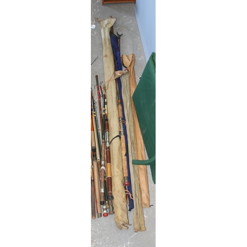 769 - Qty of mixed fishing rods to include split cane and fiberglass with rod holders, camp beds and other... 