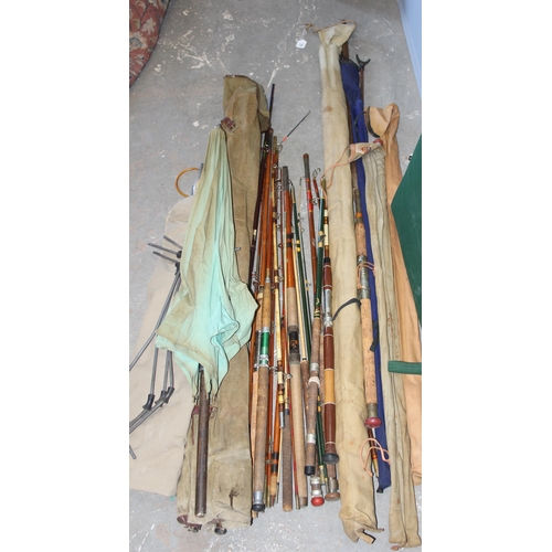 769 - Qty of mixed fishing rods to include split cane and fiberglass with rod holders, camp beds and other... 