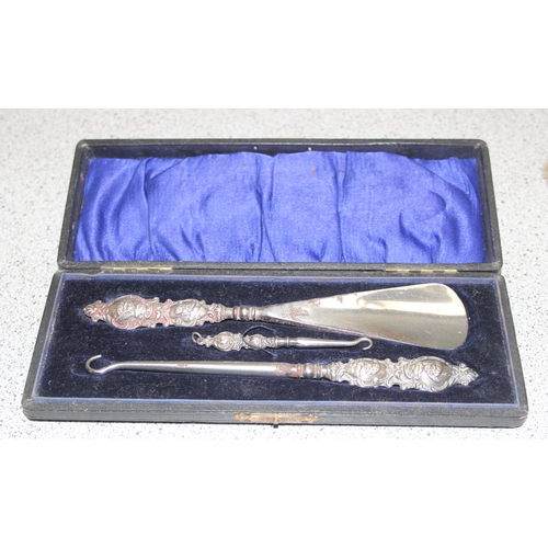 1036 - A silver backed brush, a silver mounted and ribbed glass match striker and a silver handled cased sh... 