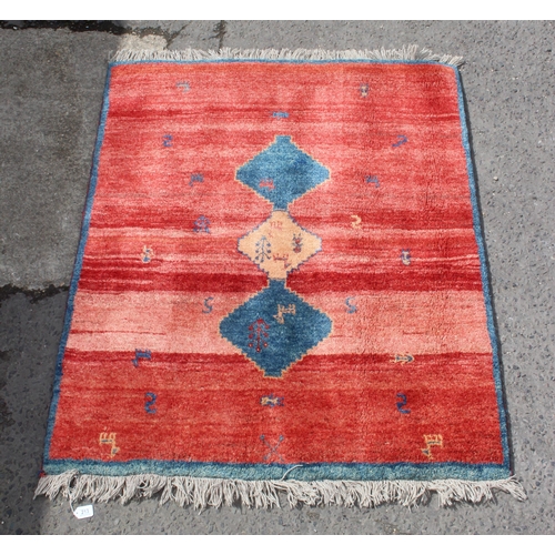 213 - Iran hand tied red ground rug with 3 gul central decoration, measures approx. 187cm x 142cm