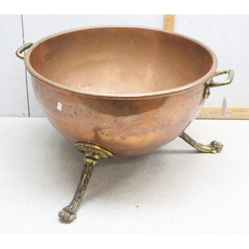 93 - A large early 20th century brass and copper log bin or rounded bottom dish standing on paw feet, app... 