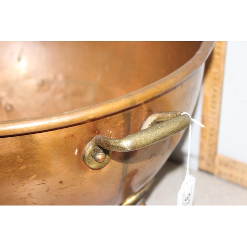 93 - A large early 20th century brass and copper log bin or rounded bottom dish standing on paw feet, app... 