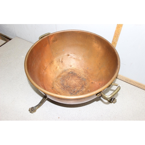 93 - A large early 20th century brass and copper log bin or rounded bottom dish standing on paw feet, app... 