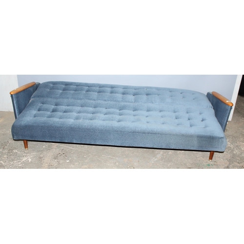 57 - A retro 1960's daybed or folding sofa with blue button backed upholstery and wooden arms, seemingly ... 