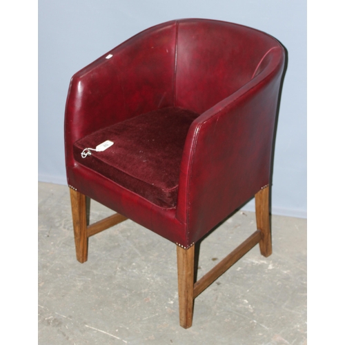 59 - A small red leather of leatherette tub chair with red velvet cushion, standing on wooden legs