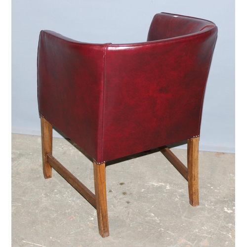 59 - A small red leather of leatherette tub chair with red velvet cushion, standing on wooden legs