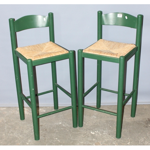 85 - A pair of green painted rush seated stools