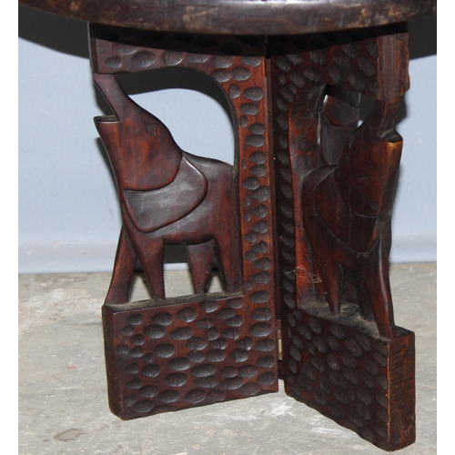 86 - An African carved wooden folding hardwood table, approx 50cm in diameter