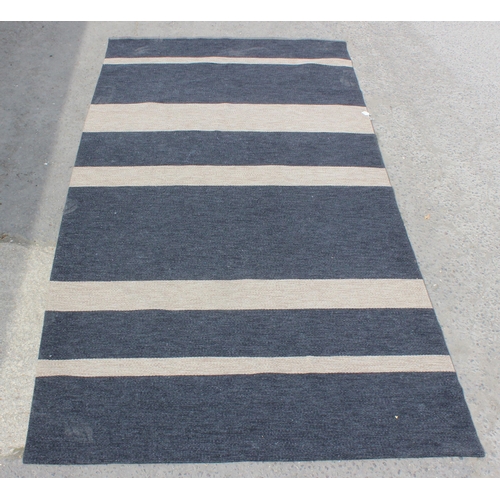 216 - A retro style black and beige striped flatweave rug, approx 390cm x 193cm