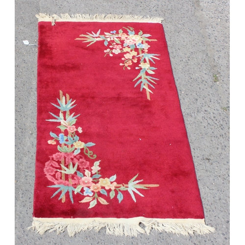 217 - A vintage thick pile red rug with floral design, approx 200cm x 95cm