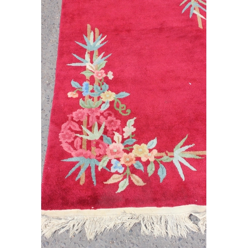 217 - A vintage thick pile red rug with floral design, approx 200cm x 95cm