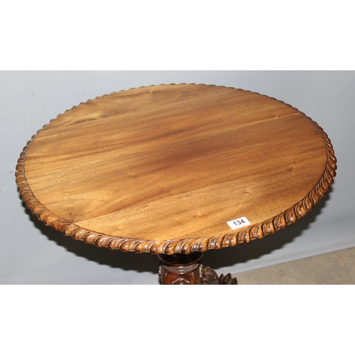 134 - An antique style tilt top table with carved details, approx 70cm in diameter