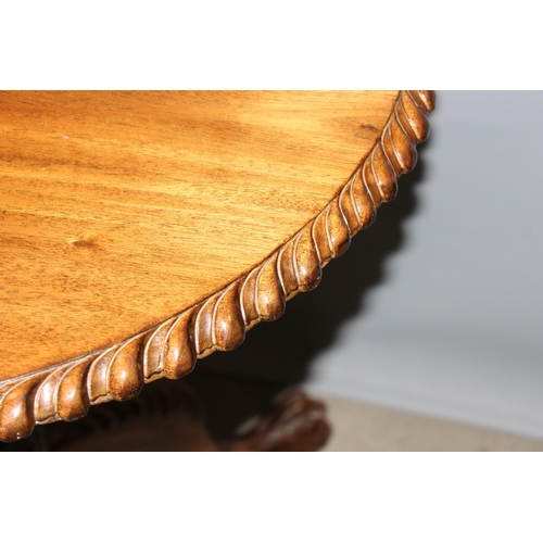 134 - An antique style tilt top table with carved details, approx 70cm in diameter