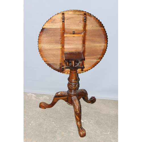 134 - An antique style tilt top table with carved details, approx 70cm in diameter