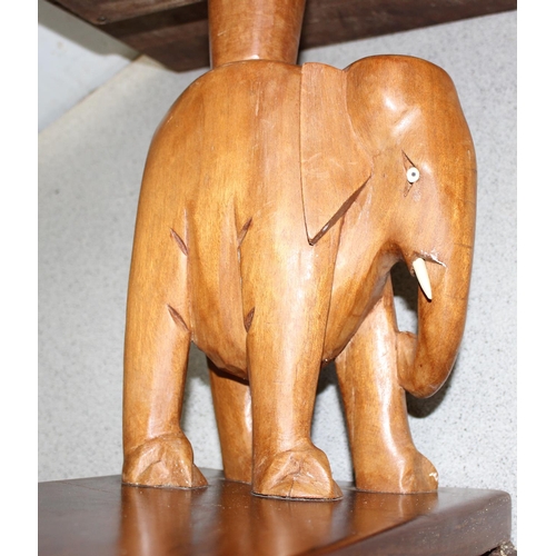 144 - A vintage West African wooden coffee table with carved elephant supports, approx 114cm wide