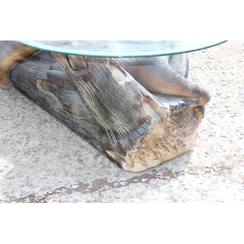 91 - A black painted glass topped table, the base formed as a black panther, the glass top approx 136cm w... 