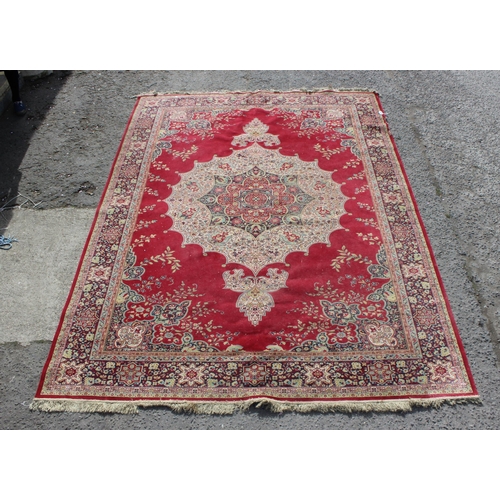 220 - An extremely large decorative red ground rug, approx 380cm x 270cm