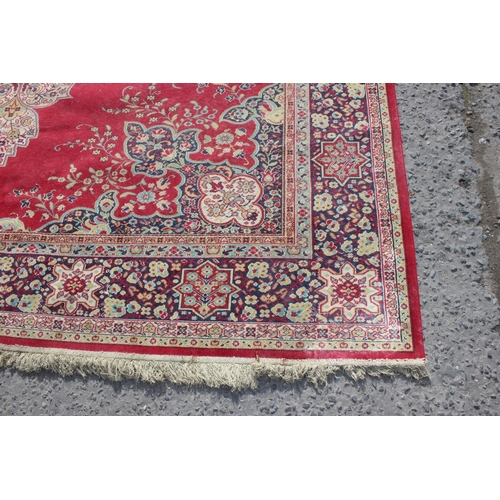 220 - An extremely large decorative red ground rug, approx 380cm x 270cm