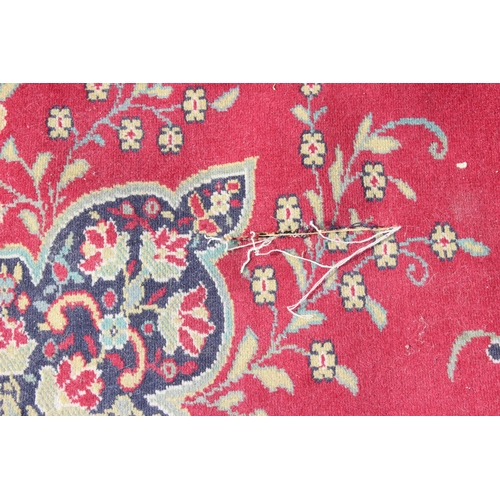 220 - An extremely large decorative red ground rug, approx 380cm x 270cm