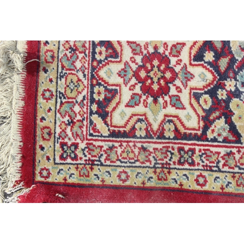 220 - An extremely large decorative red ground rug, approx 380cm x 270cm