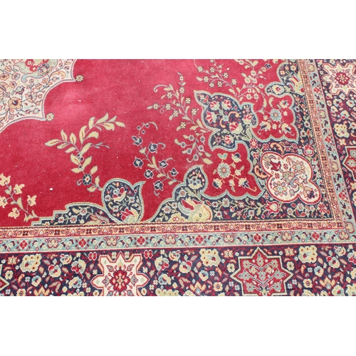 220 - An extremely large decorative red ground rug, approx 380cm x 270cm