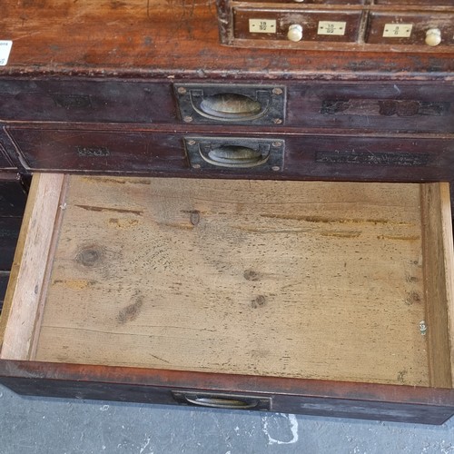 5 - A late Victorian mahogany haberdashery shop bank of fourteen drawers, each graduated drawer with flu... 