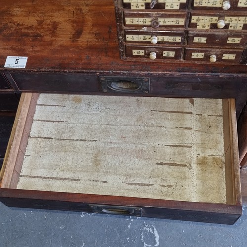 5 - A late Victorian mahogany haberdashery shop bank of fourteen drawers, each graduated drawer with flu... 